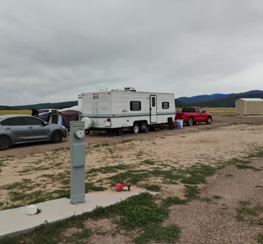 A class A motorhome in an rv site surrounde by green trees at Happy Acres RV Park in Pueblo, Colorado.